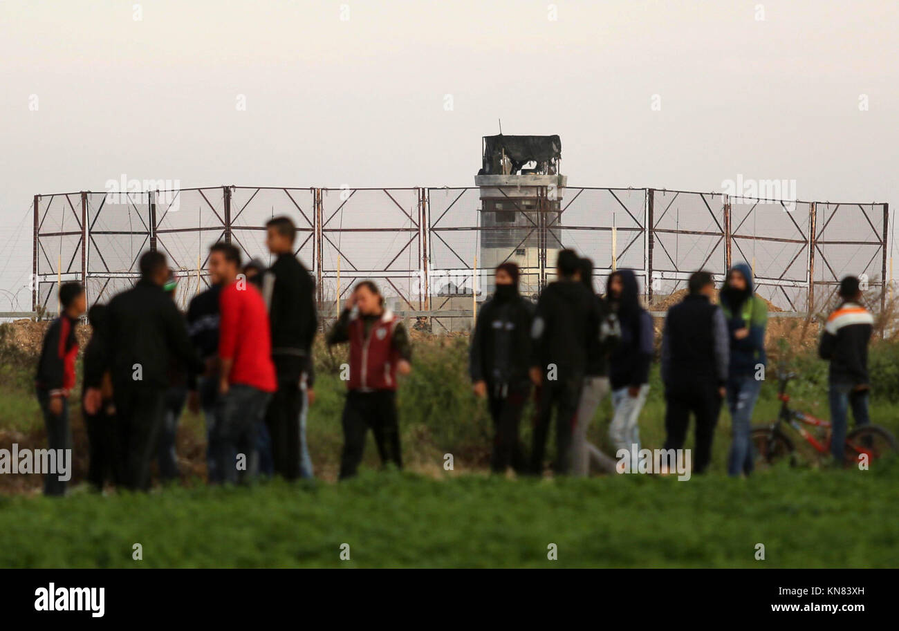 Dicembre 10, 2017 - Khan Yunis, Striscia di Gaza, Territori palestinesi - palestinesi manifestanti si scontrano con le forze israeliane nei pressi del confine Israel-Gaza est del sud della striscia di Gaza city di Khan Yunis su dicembre 10, 2017, con israeliani di macchinari pesanti visto sull'altro lato della frontiera dopo un tunnel è stato scoperto nella zona. Nuove proteste svasati in Medio Oriente e altrove su di noi il presidente Donald Trump del dicembre 6 Dichiarazione di Gerusalemme come capitale di Israele, una mossa che ha disegnato la condanna globale e scatenato giorni di disordini nei territori palestinesi (credito Immagine: © Ashraf Amra/ Foto Stock