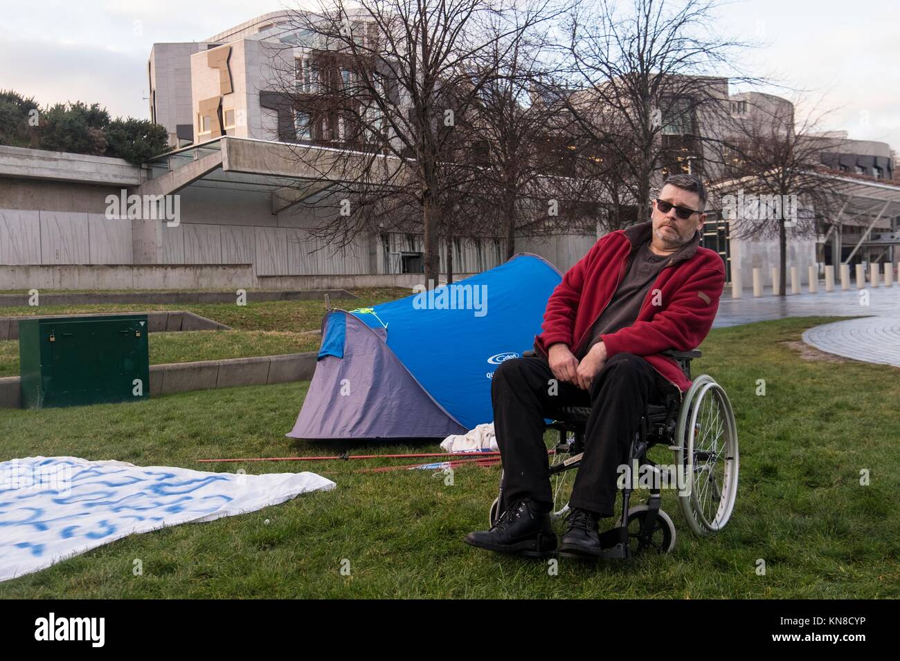 Edinburgh, Regno Unito. 11 dicembre, 2017. Diruttori, Ian Morrison da Kilwinning in Ayrshire ha istituito una tenda nella motivazione del Parlamento scozzese e ha minacciato di effettuare uno sciopero della fame fino a quando non gli è permesso di incontrare con SNP il Ministro della Salute, Shona Robison. Morrison per la campagna si riferisce all'uso degli oppioidi nel trattamento in Scottish NHS dove correlati al farmaco acuto generale i soggiorni sono aumentati da 41 persone a 143 persone per 100k tra il 1996 e il 2016. Credito: ricca di Dyson/Alamy Live News Foto Stock