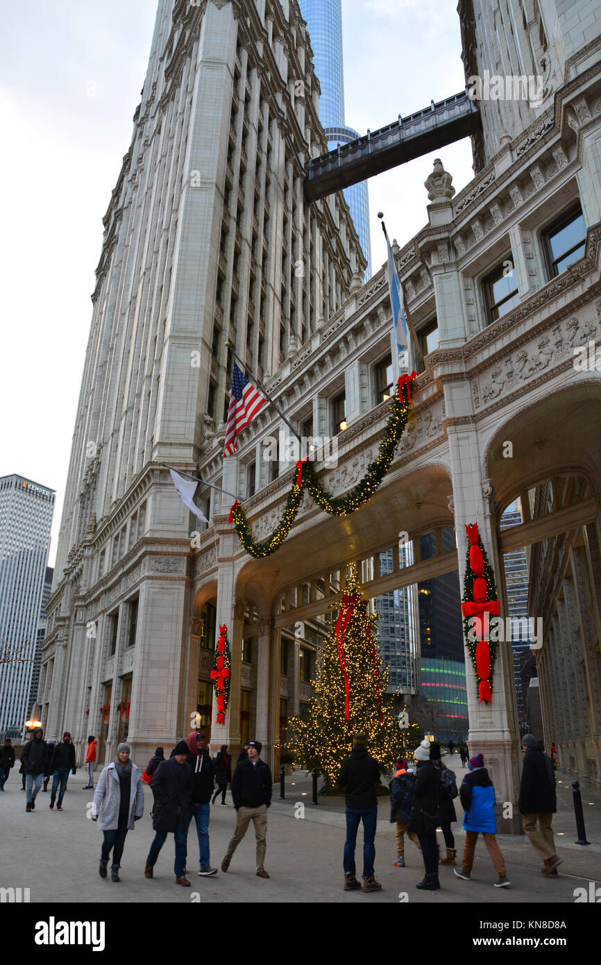 Chicago, Stati Uniti d'America. Decimo Dec, 2017. Gli acquirenti di vacanza su Michigan Avenue's 'Magnificent Mile' a piedi passato le luci di Natale sul Wrigley Building su un vivace serata in Chicago. Credito: D Valutazione Smith/Alamy Live News Foto Stock