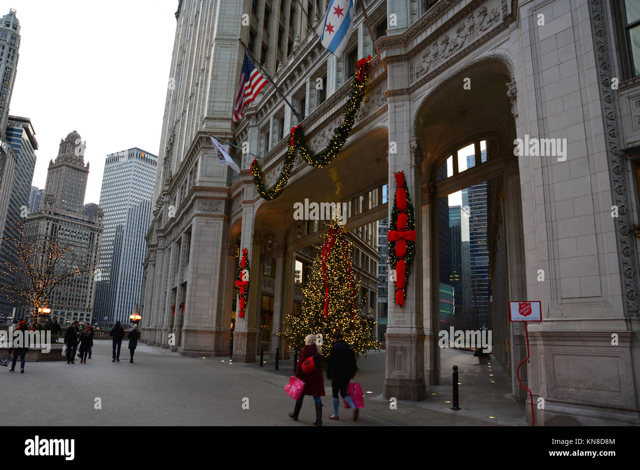 Chicago, Stati Uniti d'America. Decimo Dec, 2017. Gli acquirenti di vacanza su Michigan Avenue's 'Magnificent Mile' a piedi passato le luci di Natale sul Wrigley Building su un vivace serata in Chicago. Credito: D Valutazione Smith/Alamy Live News Foto Stock