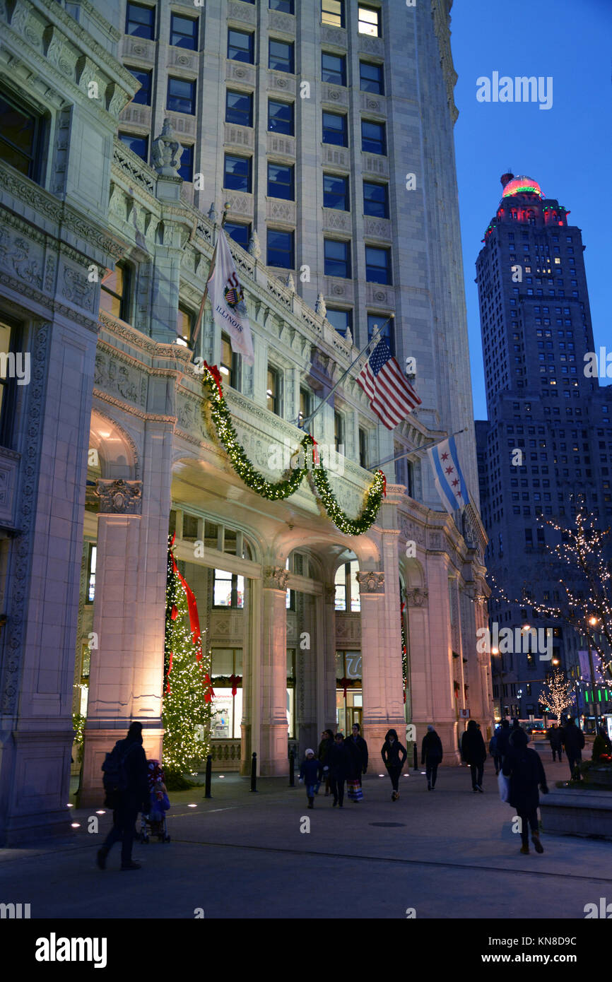 Chicago, Stati Uniti d'America. Decimo Dec, 2017. Gli acquirenti di vacanza su Michigan Avenue's 'Magnificent Mile' a piedi passato le luci di Natale sul Wrigley Building su un vivace serata in Chicago. Credito: D Valutazione Smith/Alamy Live News Foto Stock