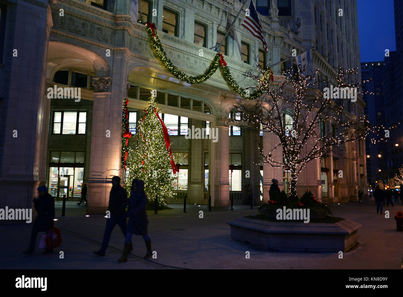 Chicago, Stati Uniti d'America. Decimo Dec, 2017. Gli acquirenti di vacanza su Michigan Avenue's 'Magnificent Mile' a piedi passato le luci di Natale sul Wrigley Building su un vivace serata in Chicago. Credito: D Valutazione Smith/Alamy Live News Foto Stock