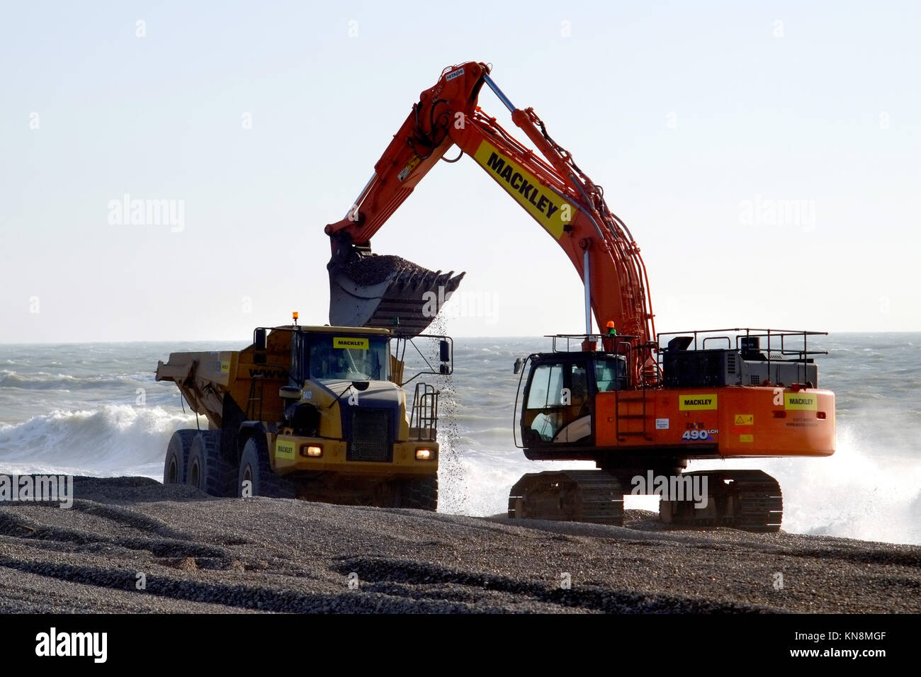 Macchinari pesanti spostando la spiaggia di ghiaia per le difese costiere in Seaford, East Sussex. Foto Stock