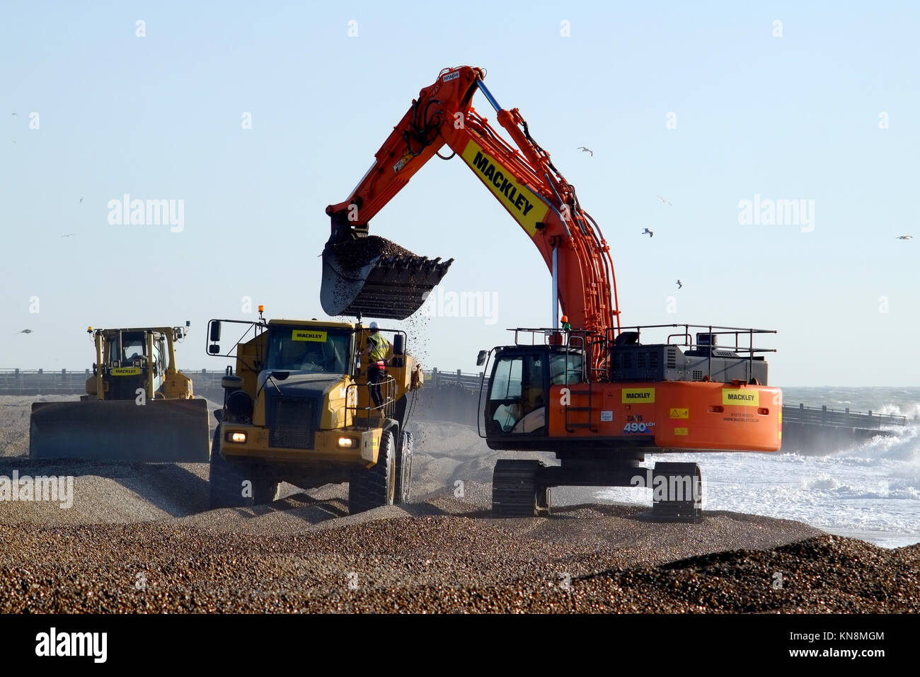 Macchinari pesanti spostando la spiaggia di ghiaia per le difese costiere in Seaford, East Sussex. Foto Stock