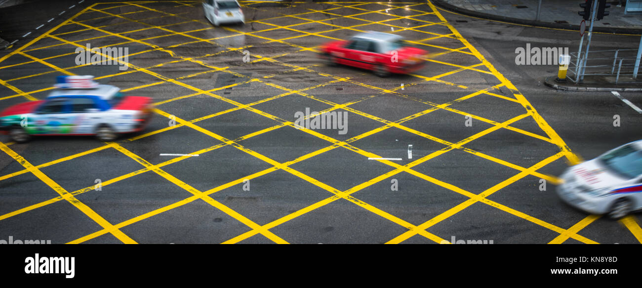 Cars driving attraverso il giallo nessuna area di parcheggio su strada asfaltata,Cina. Foto Stock