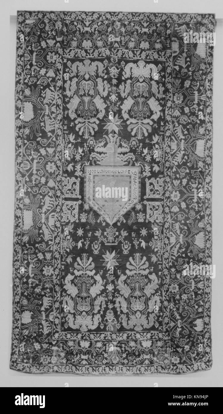 Questo tappeto intrecciato mostra disegni intricati e colori regionali, servendo sia come tessuto decorativo che funzionale all'interno di storici ambienti interni. Foto Stock