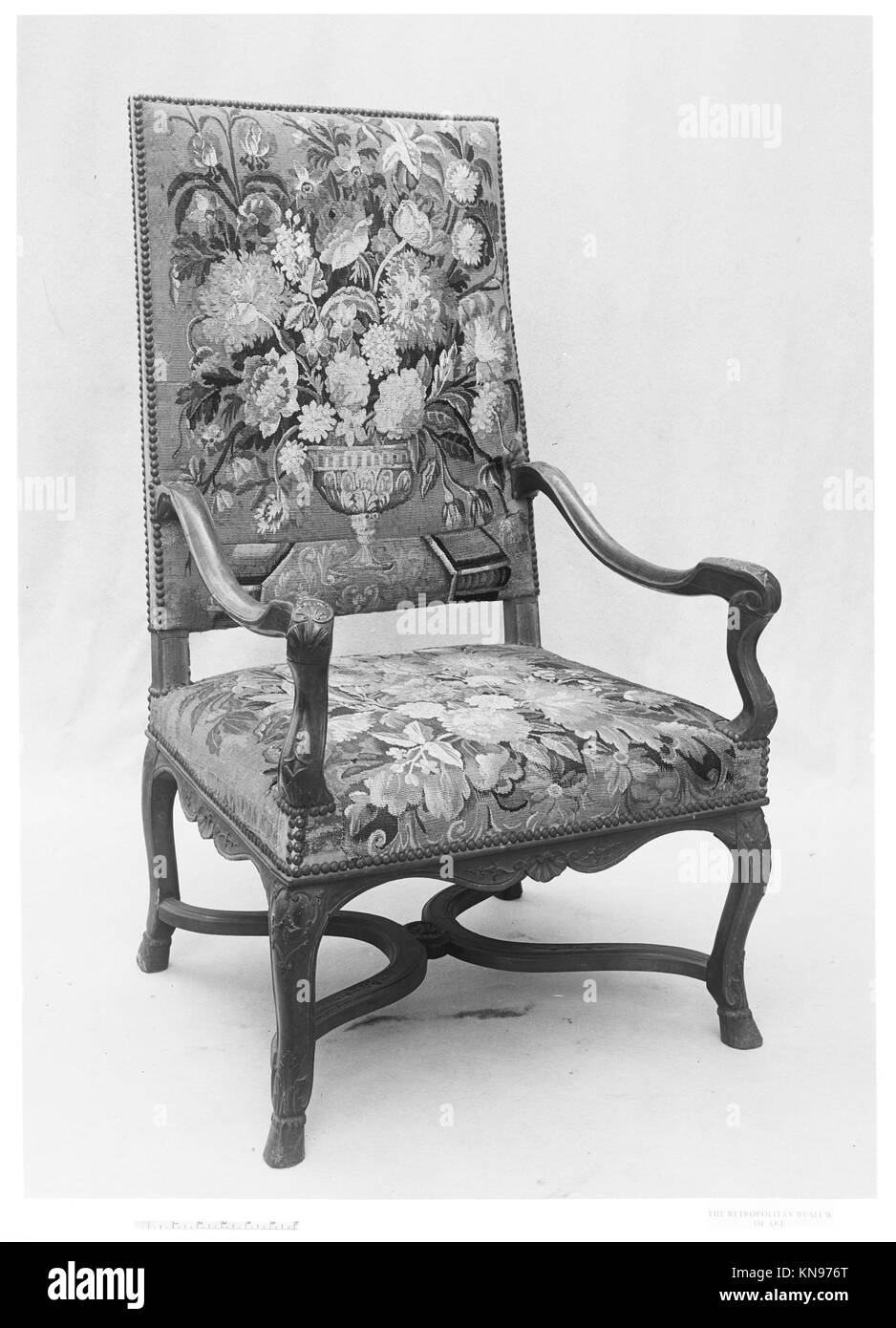 Una poltrona francese della fine del XVII o inizio del XVIII secolo con struttura in noce intagliato e tappezzeria in tappezzeria in seta e lana Aubusson, che mostra un design elegante e artigianato in mobili decorativi, parte della collezione MET. Foto Stock