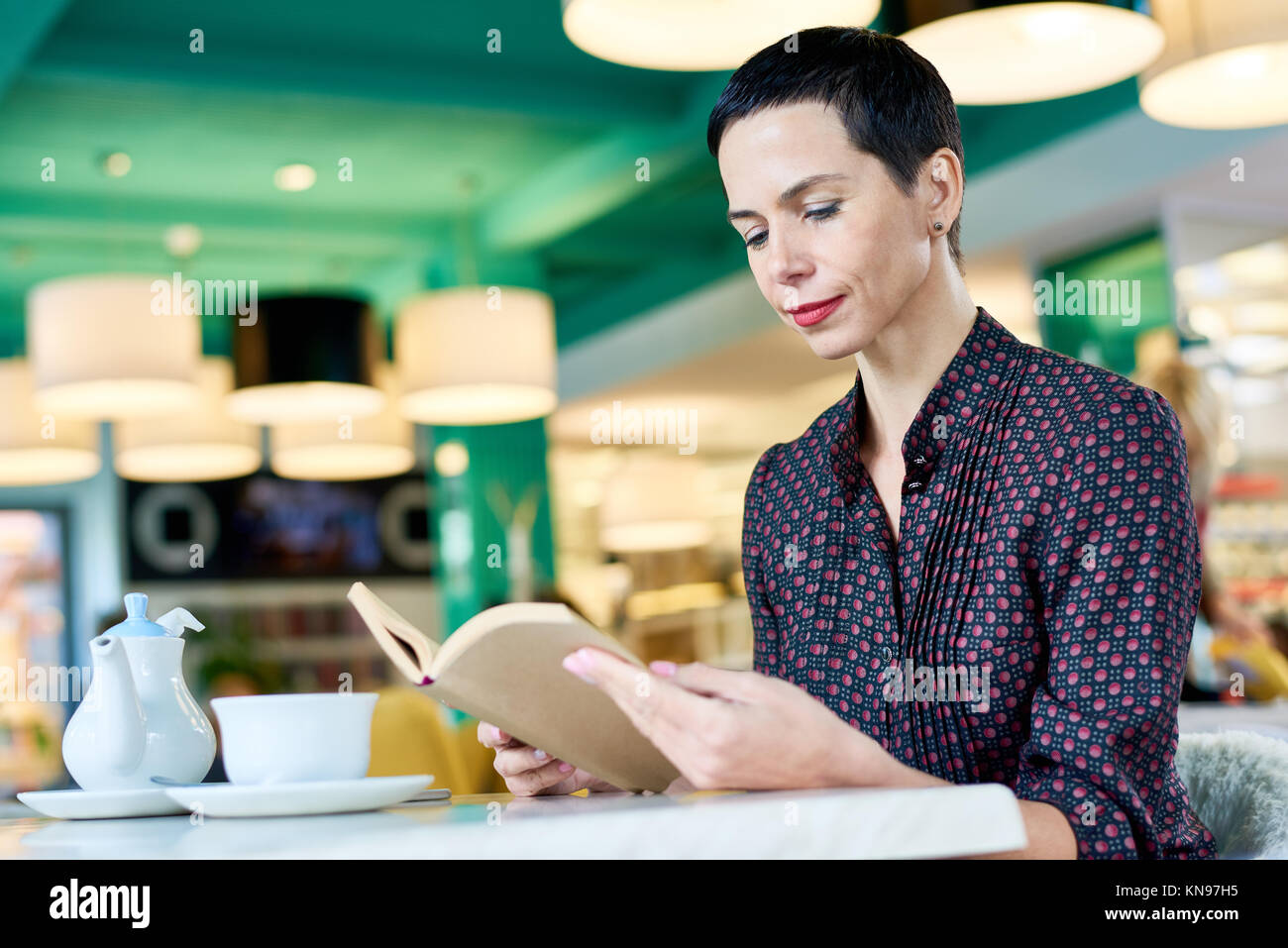 Donna elegante Libro in Cafe Foto Stock