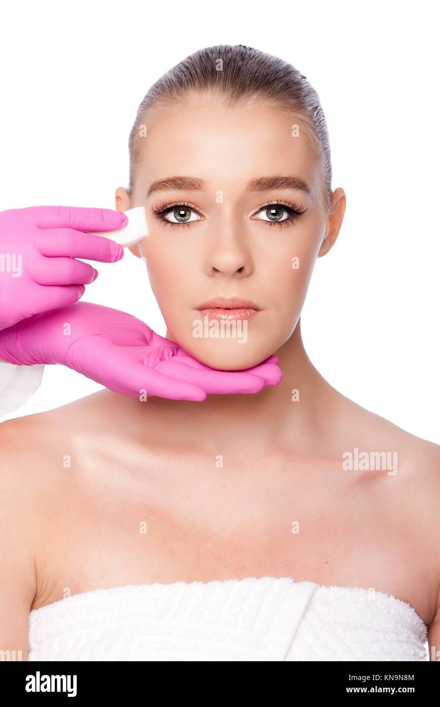 Bella pulizia viso Cosmetic skincare spa trattamento di bellezza con guanti di rosa e spugna, su bianco. Foto Stock