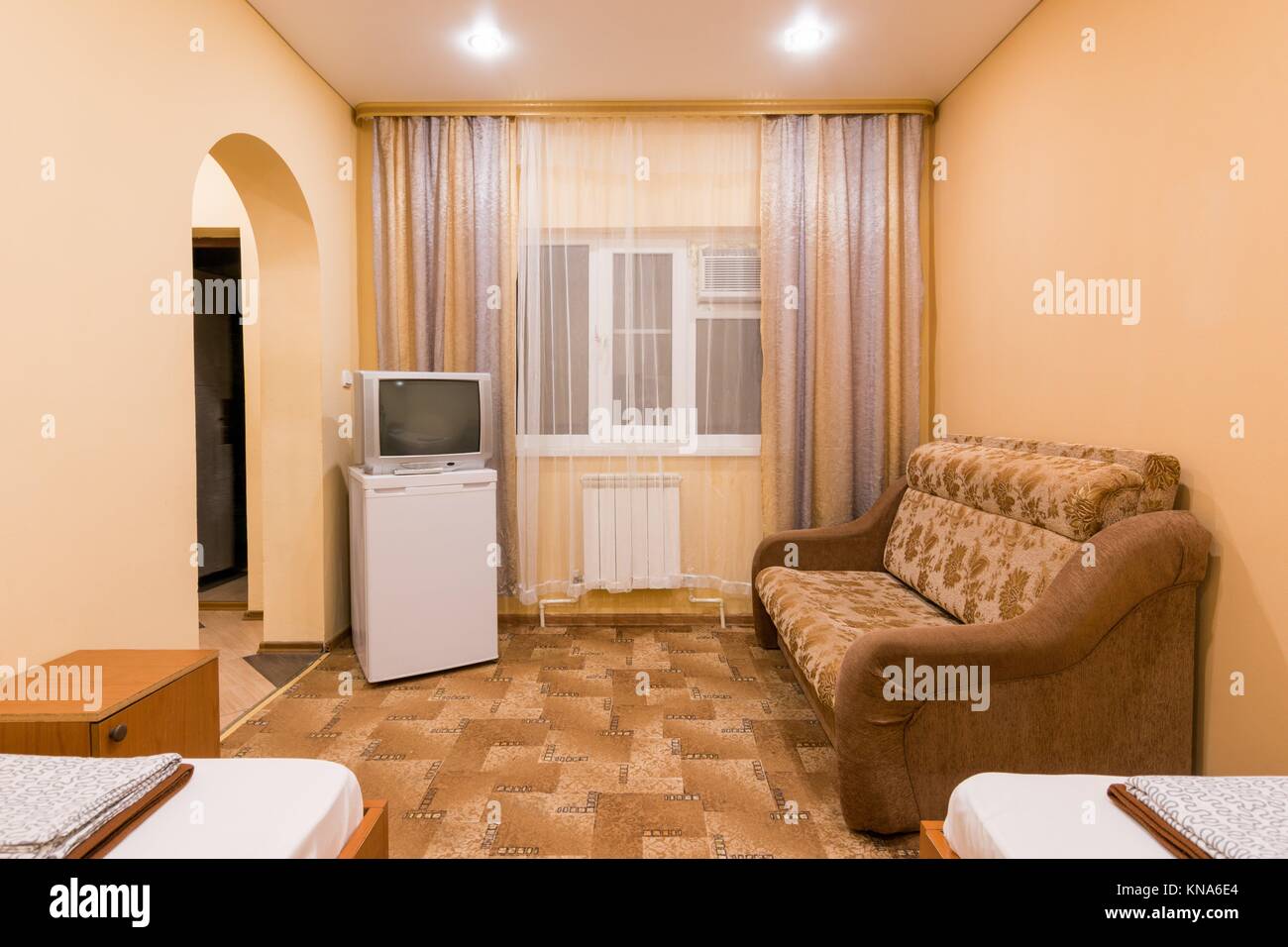 L Interno Di Una Piccola Camera Con Divano Letto Matrimoniale E Due Letti Singoli Finestra Tv E Frigo Foto Stock Alamy