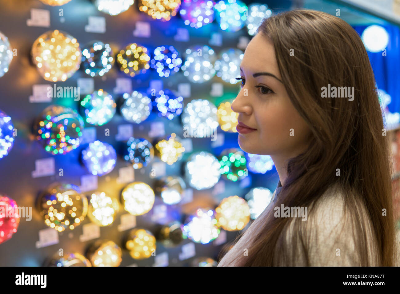 La ragazza al cliente la scelta di addobbi per l'albero di Natale - ghirlande Foto Stock