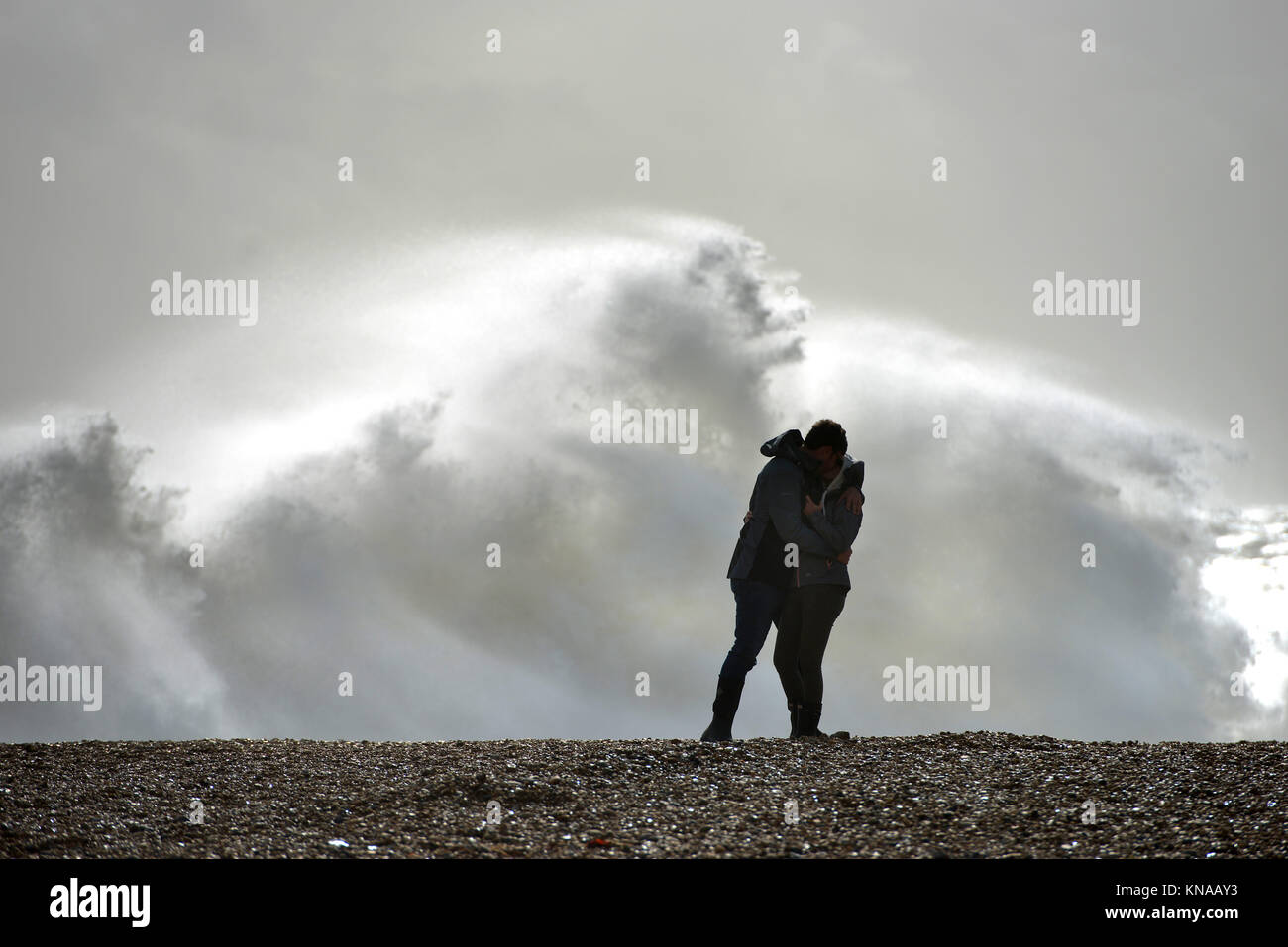 Giovane baciando su una spiaggia con un mare tempestoso Foto Stock