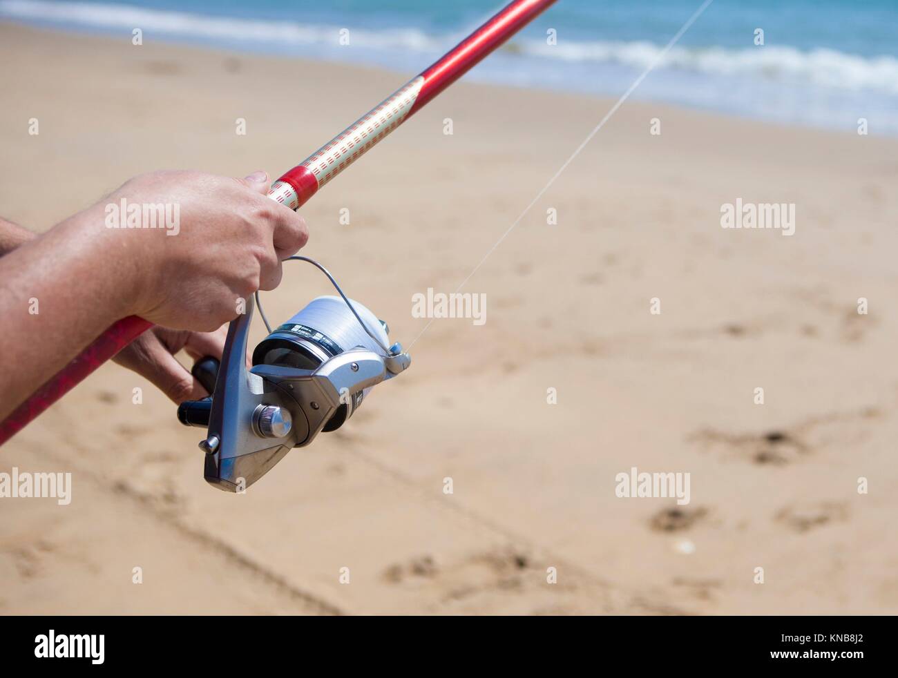 La piegatura della lenza. La pesca con lenza in mare sport in spiaggia. Foto Stock