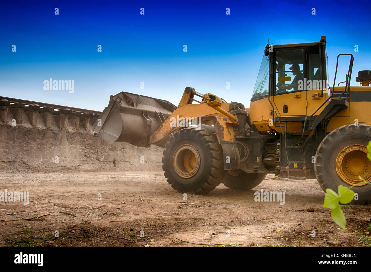 Carichi di escavatore ghiaia nel carrello Foto Stock