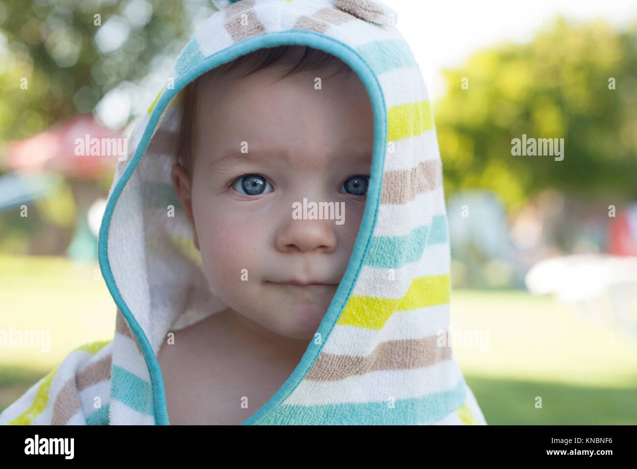 1 anno baby boy con hooded poncho asciugamano dopo il nuoto. Ritratto. Foto Stock
