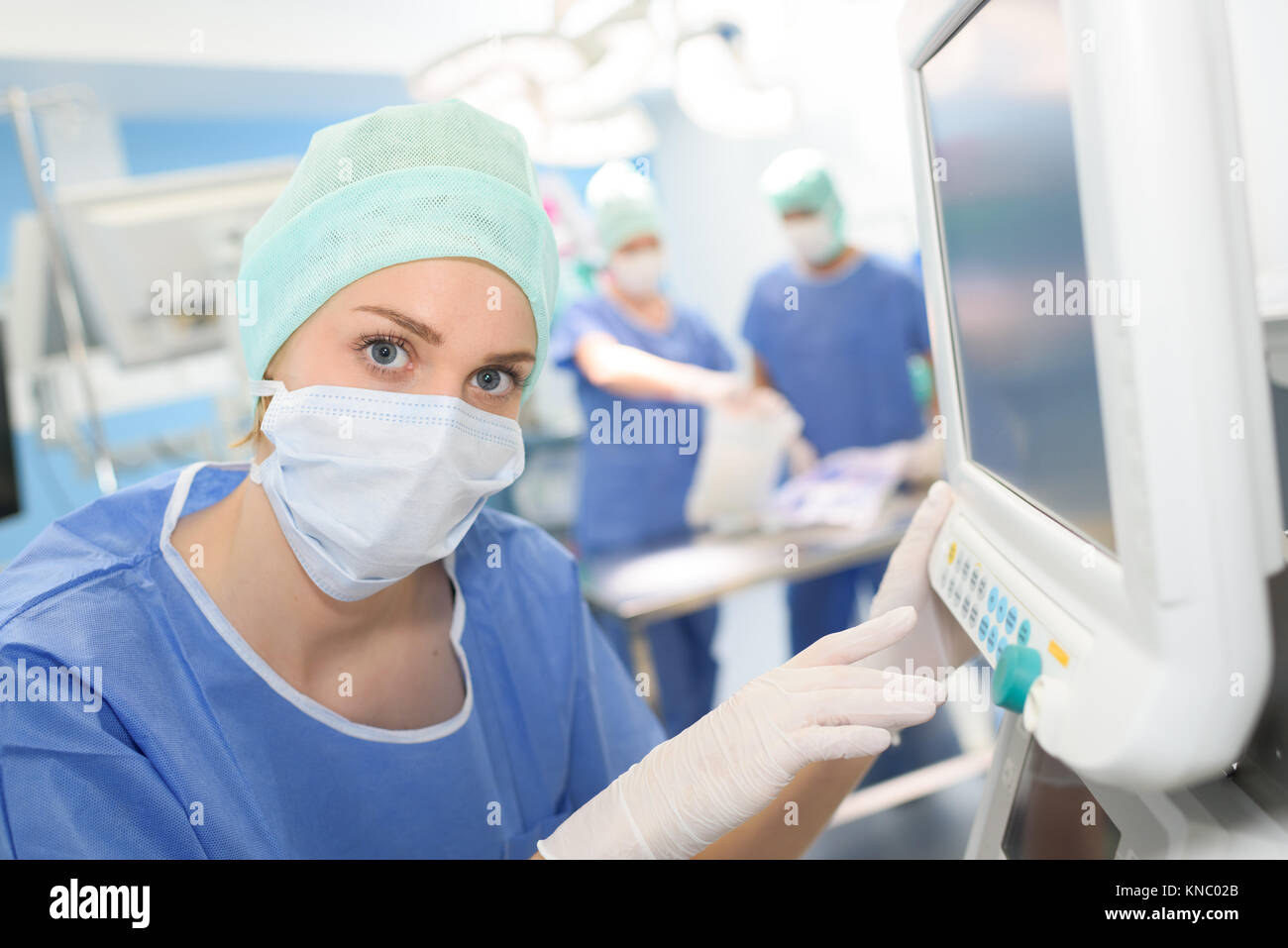 Chirurgo guardando il monitor medicale durante la chirurgia Foto Stock