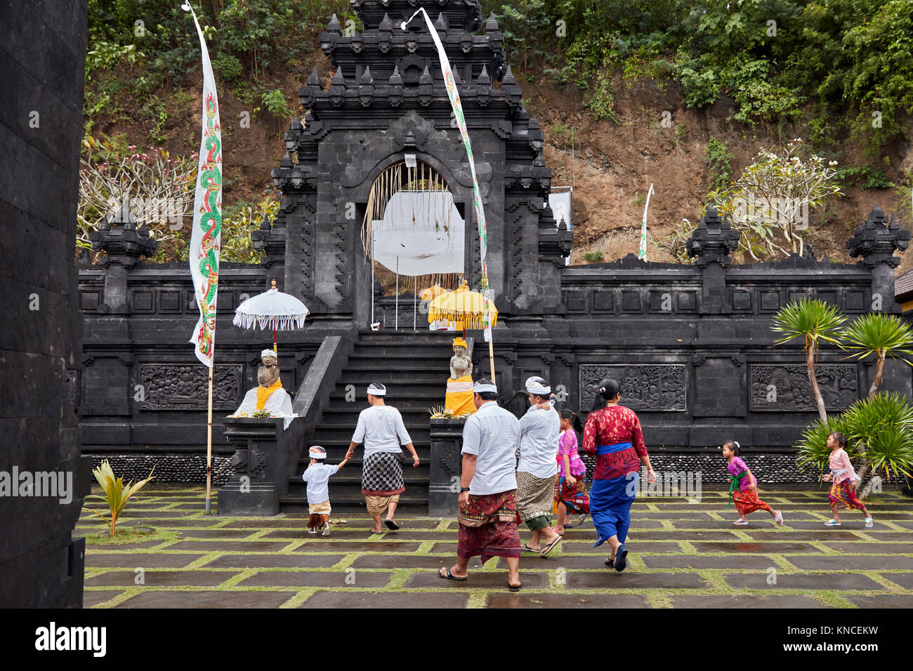 Persone che indossano Balinese tradizionale abbigliamento andare al Candi Dasa Tempio. Candidasa, Manggis sottodistretto, Karangasem Regency, Bali, Indonesia. Foto Stock