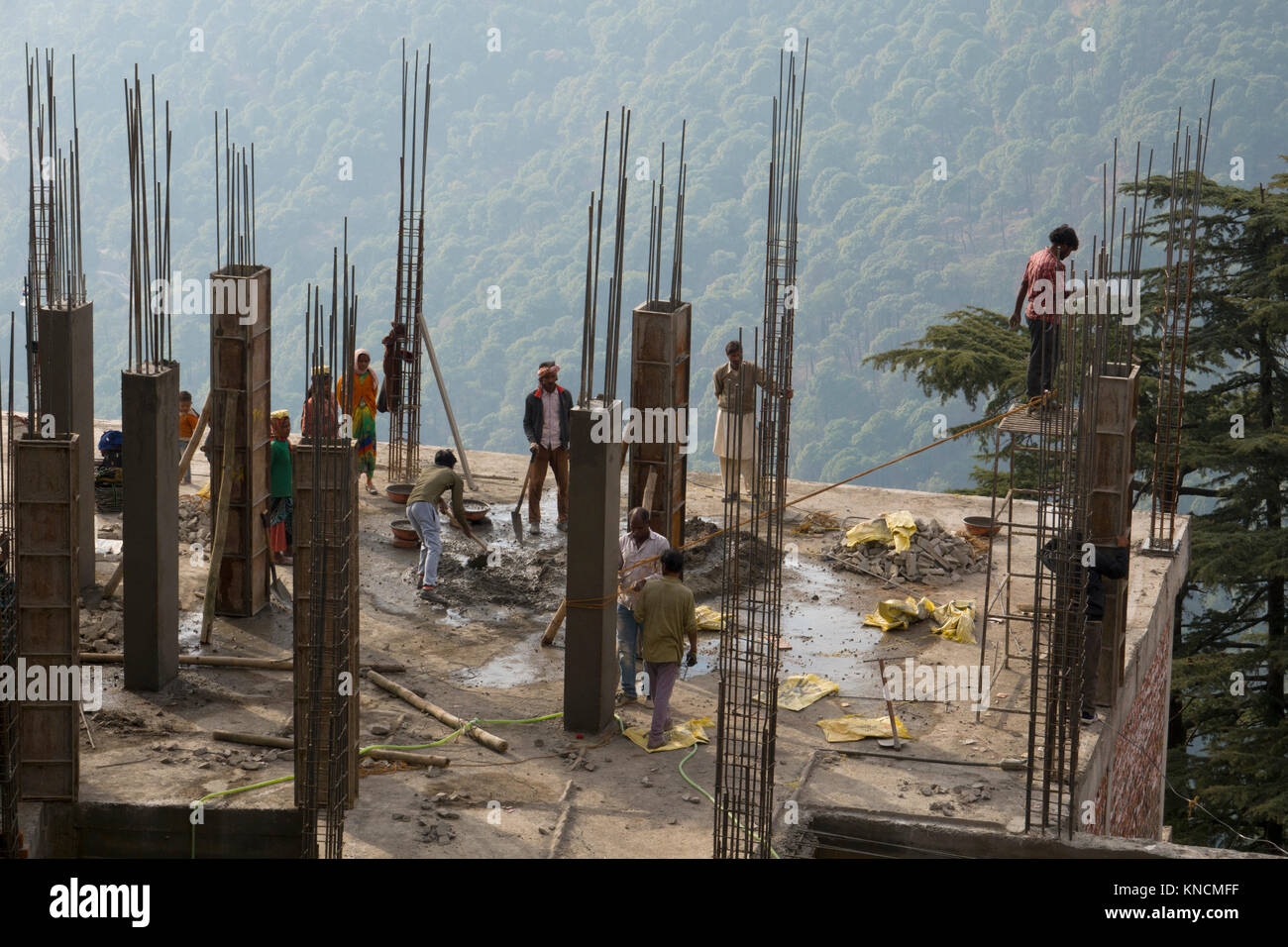 Indian lavoratori edili la costruzione di un edificio in cemento in Mcleod Ganj, India Foto Stock