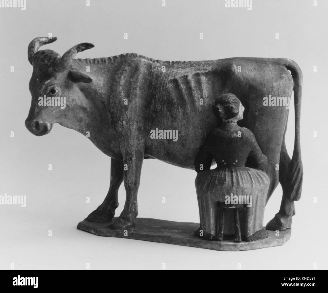 Questa opera raffigura una ragazza che munge una mucca, illustrando pratiche agricole rurali, lavori domestici e interazioni uomo-animale nella vita quotidiana delle fattorie. Foto Stock