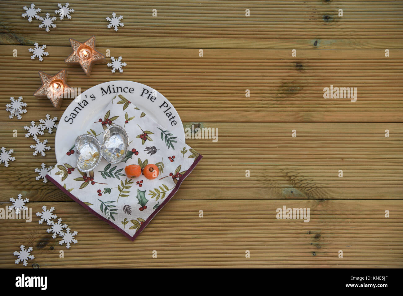 Natale tradizione di lasciare Santa Claus un trito torta e una carota per le renne vigilia di Natale su questa piastra con candele in legno rustico con spazio Foto Stock