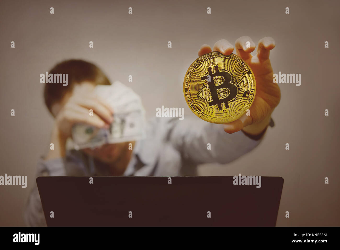 Miniere, uomo tiene nelle sue mani il simbolo della nuova moneta crypto bitcoin estratta dal computer in high-tech era che ha sostituito il mining mi Foto Stock