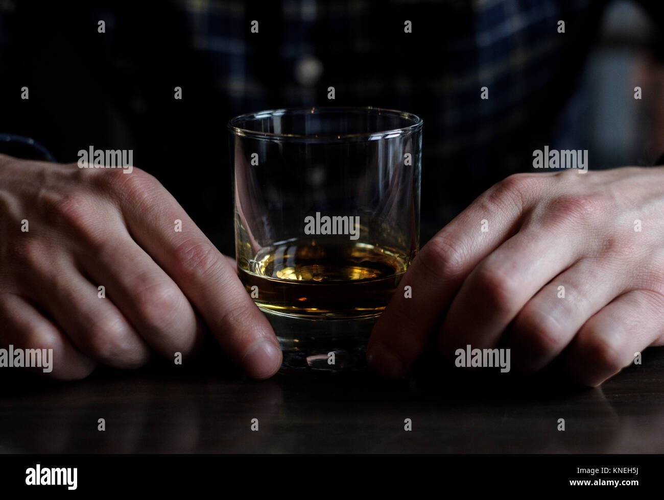 Uomo seduto in un bar con un bicchiere di whisky Foto Stock