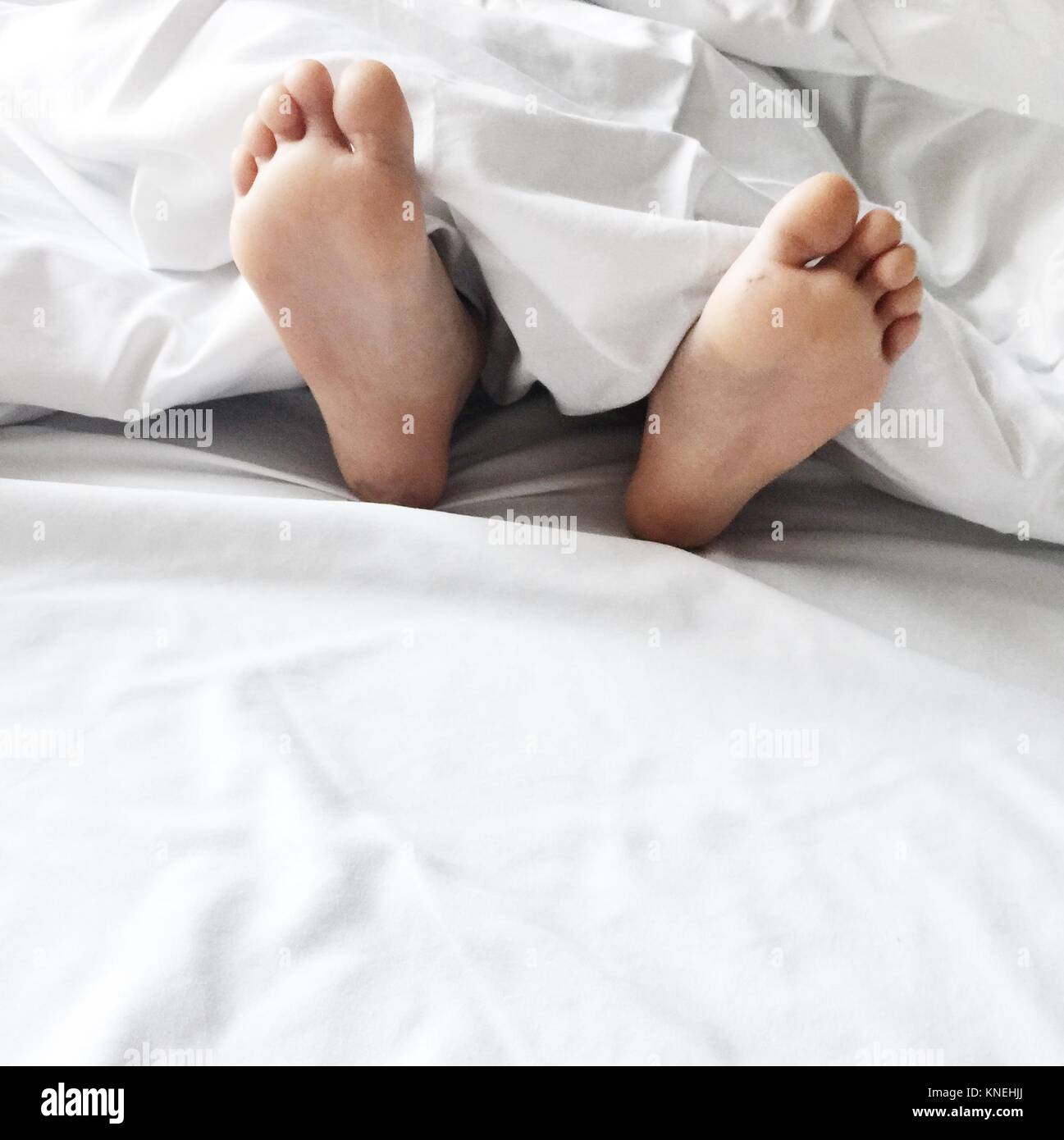 Close-up di un ragazzi piedi giacente a letto Foto stock - Alamy