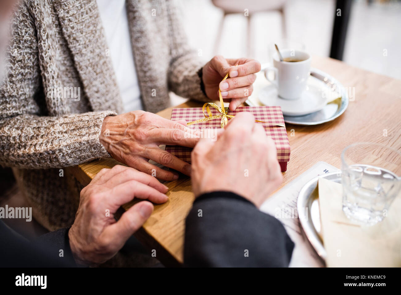 Coppia senior con un presente in una caffetteria. Il tempo di Natale. Foto Stock