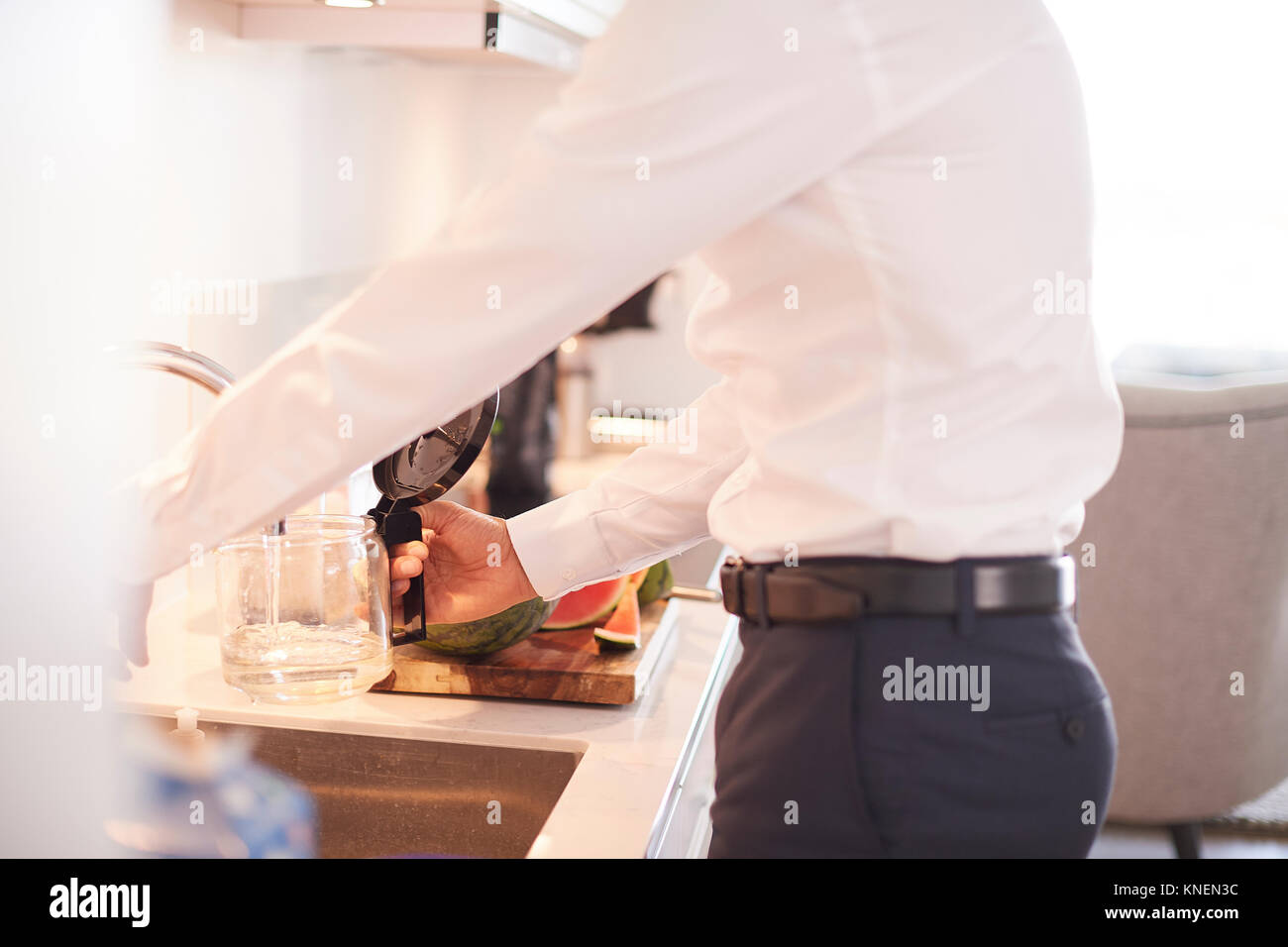 La sezione centrale dell'uomo il riempimento di caffettiera in cucina Foto Stock
