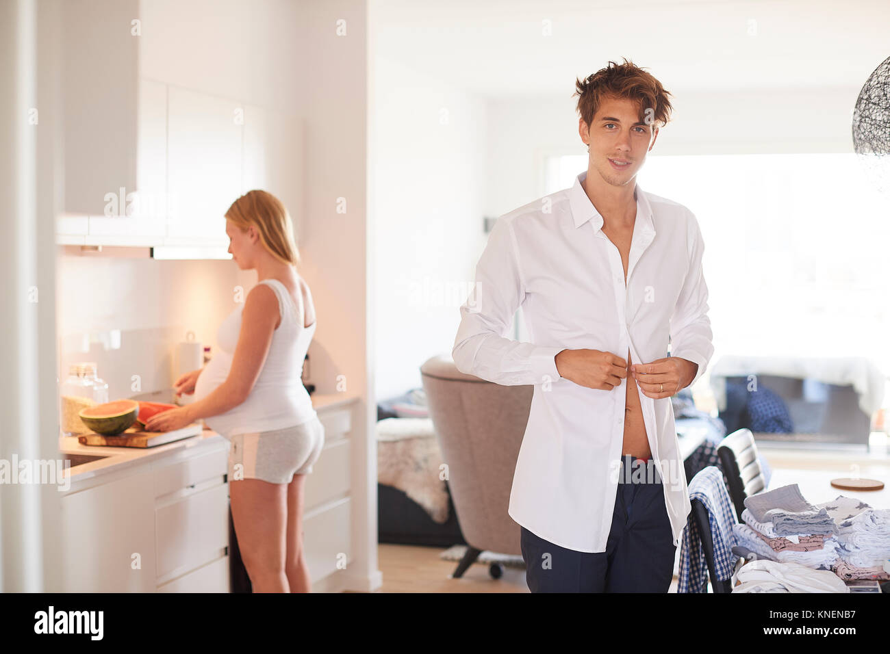 Ritratto di uomo abbottonatura shirt e incinta ragazza in cucina Foto Stock