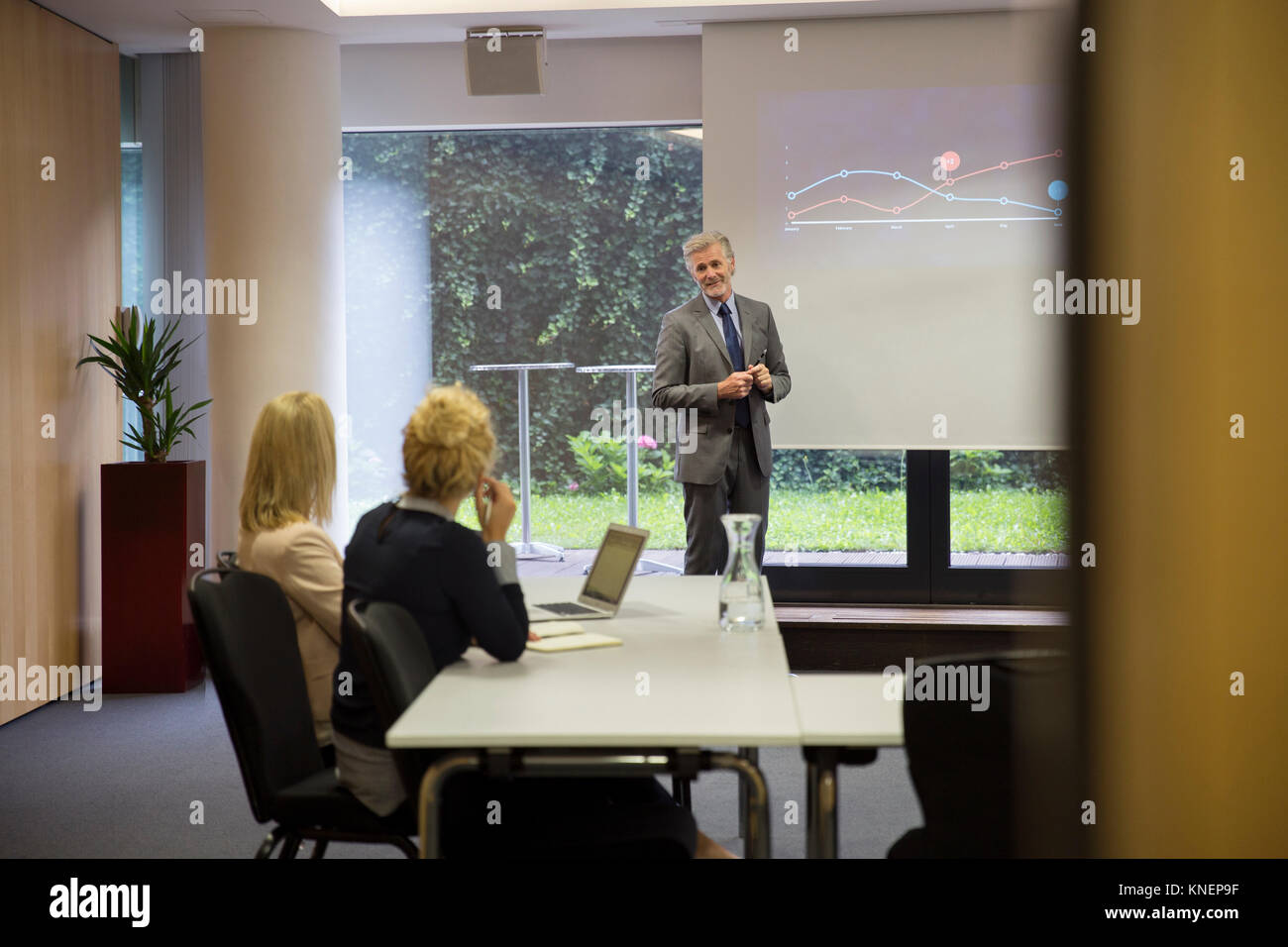 I colleghi nella sala conferenze, presentazione su schermo di proiezione Foto Stock