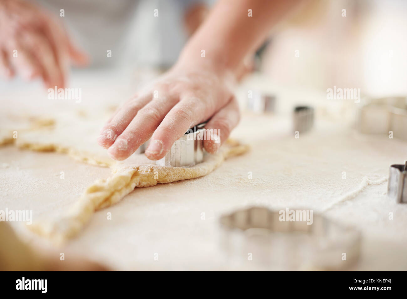 Le mani della ragazza e la nonna di taglio biscotti di pasqua al banco di cucina Foto Stock