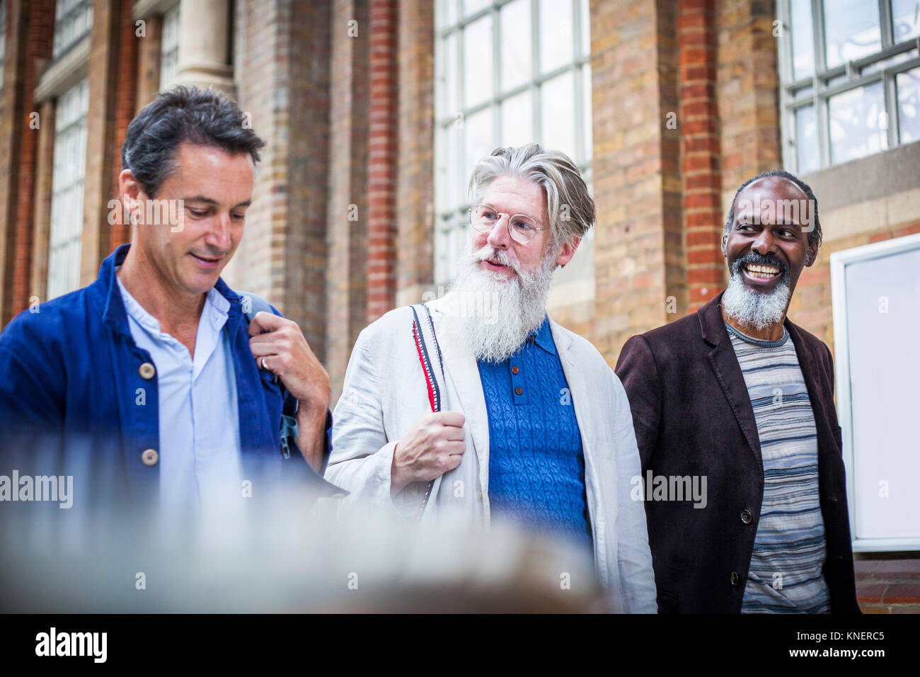 Tre uomini maturi a stazione ferroviaria, camminando insieme Foto Stock