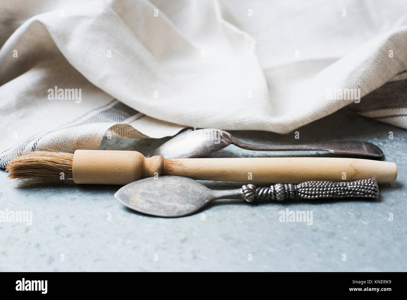 Spazzola di pasticceria e cucchiai sul banco di cucina, close-up Foto Stock