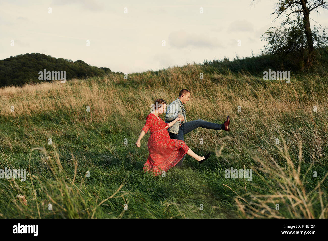 Divertimento incinta giovane marciando nel campo Foto Stock