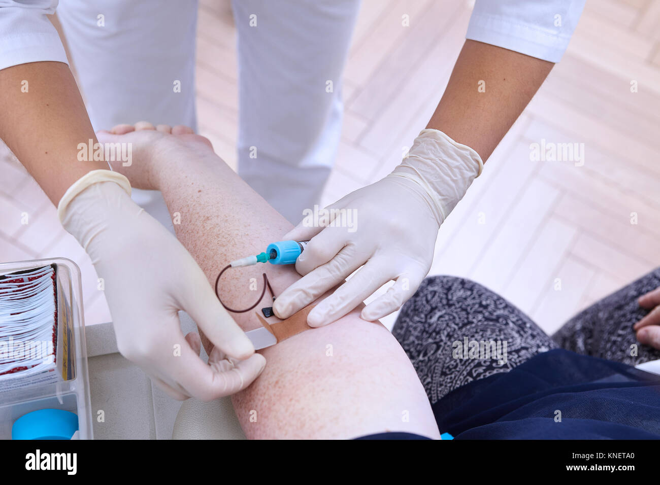 Vista ritagliata del professionista medico eseguendo il test del sangue Foto Stock