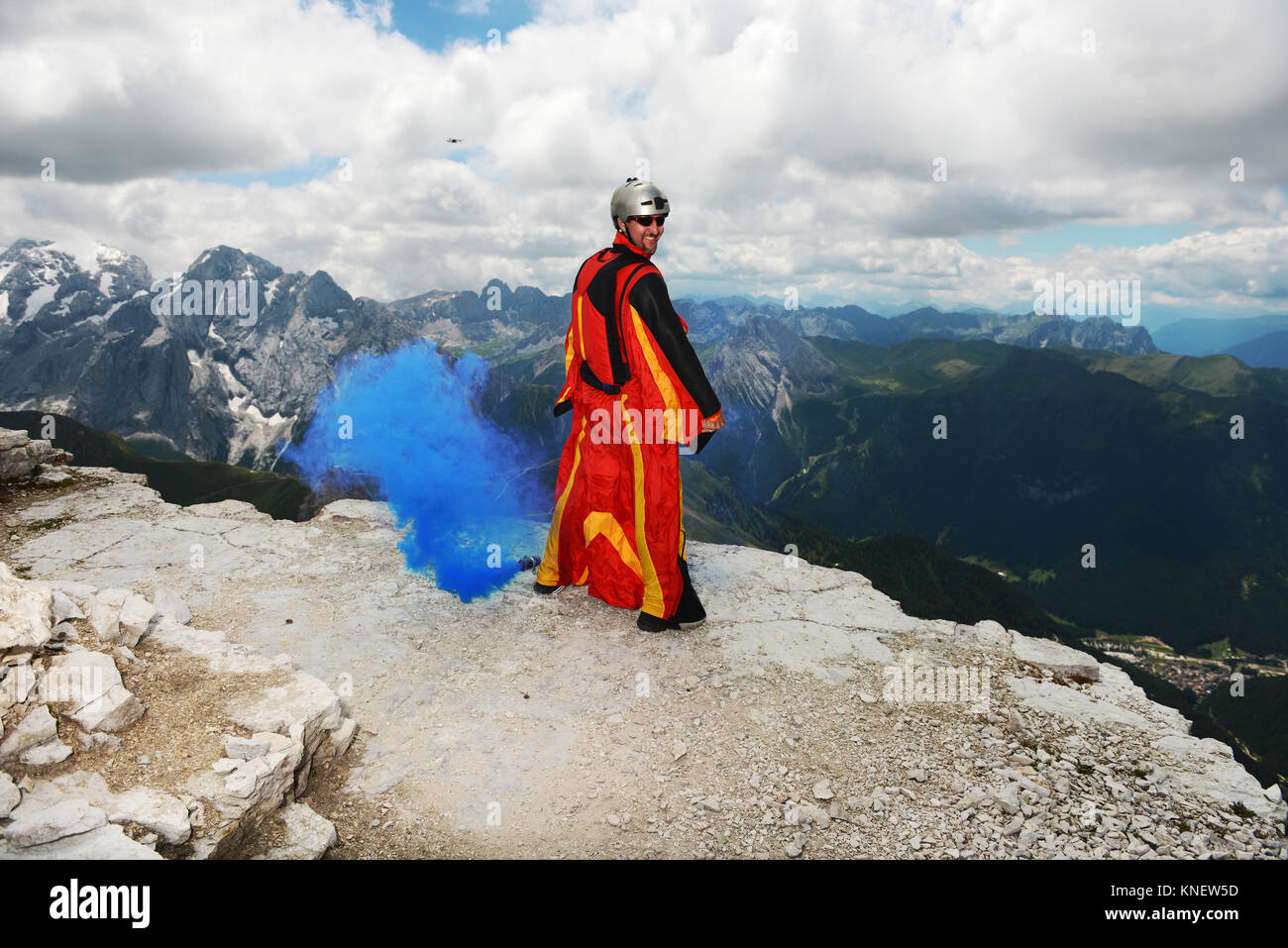 Ponticello di base sulle montagne dolomitiche indossando wingsuit emettere fumo blu, Canazei, Trentino Alto Adige, Italia, Europa Foto Stock