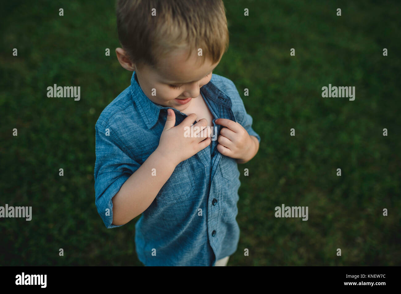 Ragazzo unbuttoning camicia per indagare il torace Foto Stock