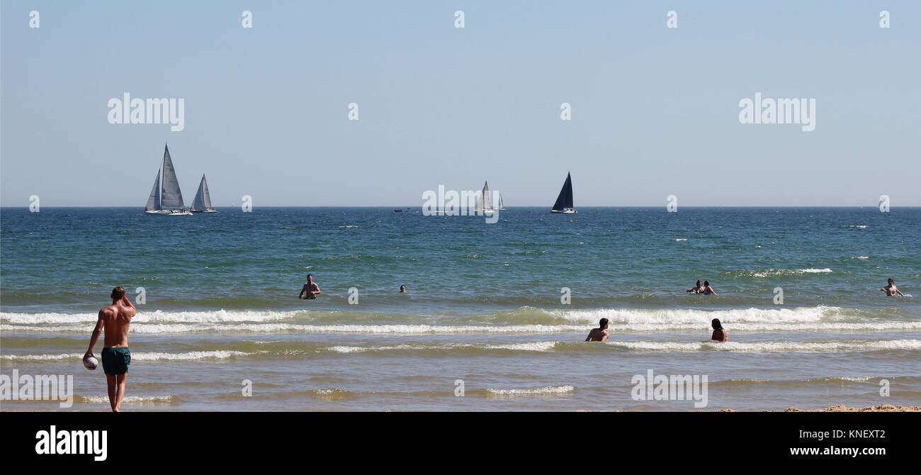 Una spiaggia estiva shot, con persone fuori a godersi il prezioso poco sole di un inglese estate. Foto Stock