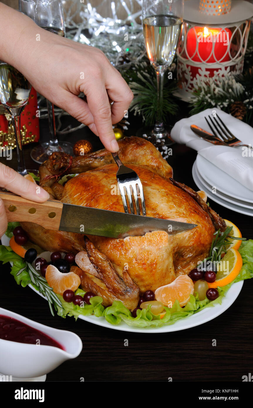 Donna mani affettare gustoso succosa appetitosi speziato arrosto di pollo intero Foto Stock