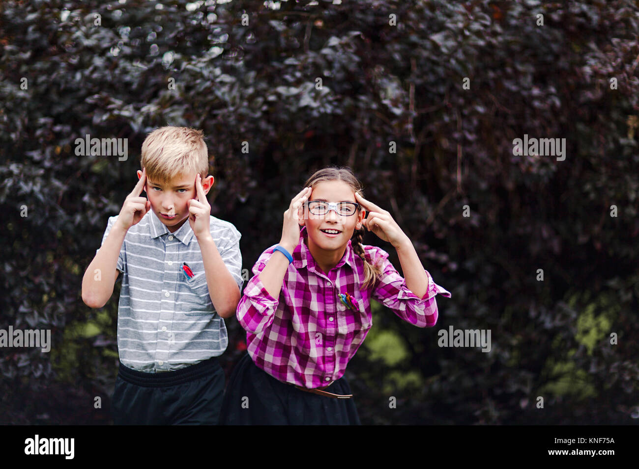 I fratelli vestito come nerds, le mani sulla testa guardando la fotocamera Foto Stock