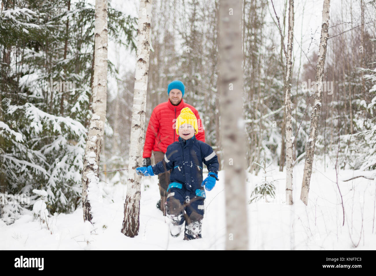 Uomo e figlio a piedi nella neve coperto foresta Foto Stock