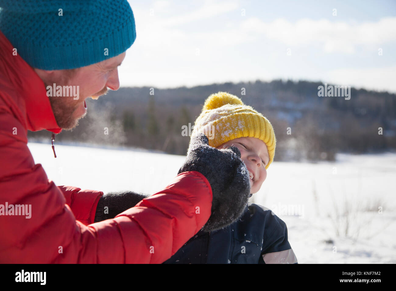 Uomo e figlio di ridere in paesaggi innevati Foto Stock