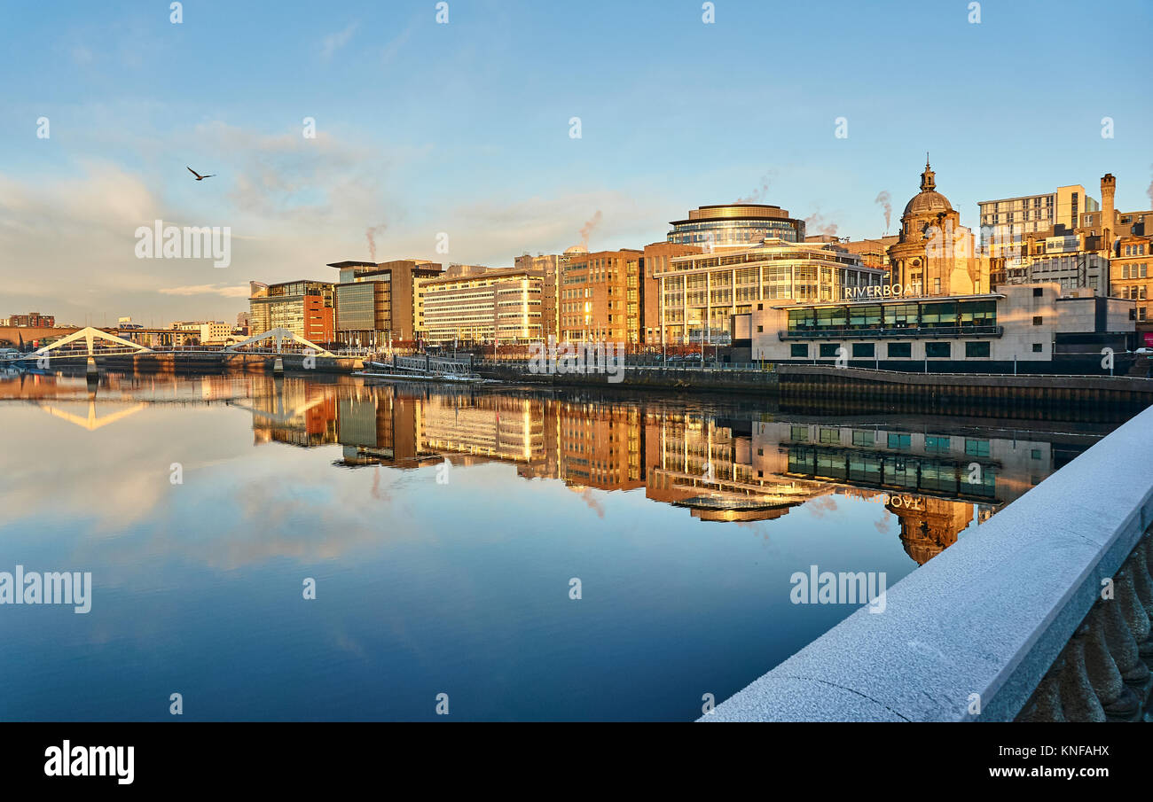 Glasgow, Regno Unito, 11 dicembre 2017, Wintery sunrise nel centro della città di Glasgow illuminando il riverside coorporate edifici di un bel colore arancione glow. Foto Stock