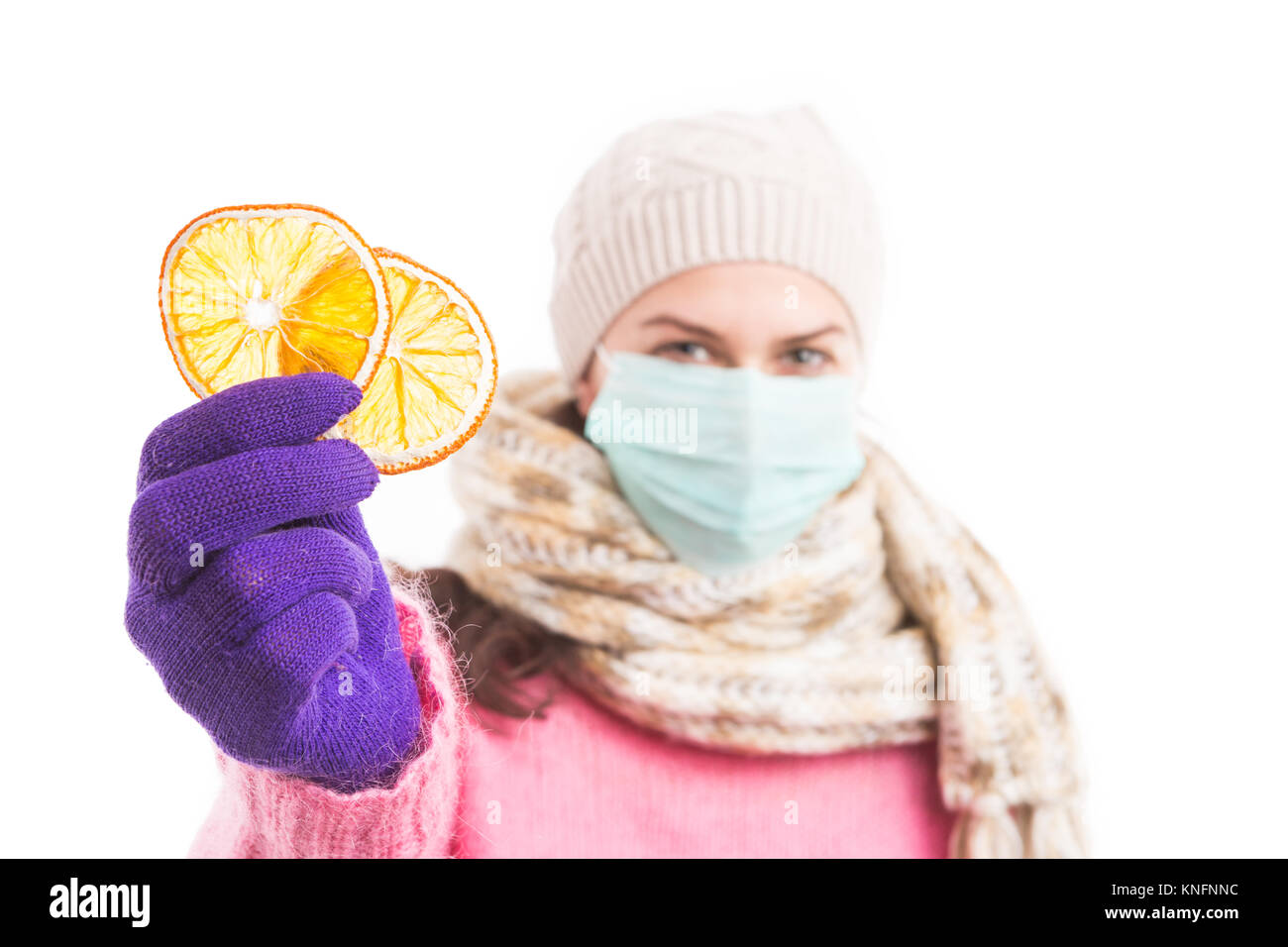 Un trattamento naturale per il freddo invernale o il concetto di influenza con la donna holding fettine di arancia e indossando calda lana vestiti a maglia Foto Stock