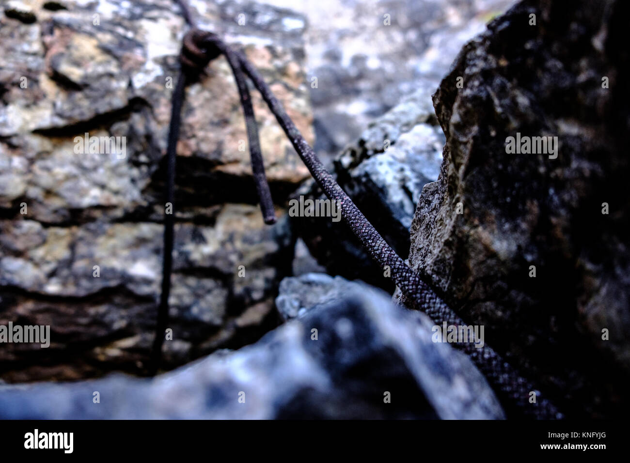 Vecchio alpinismo corda legata a una roccia Foto Stock