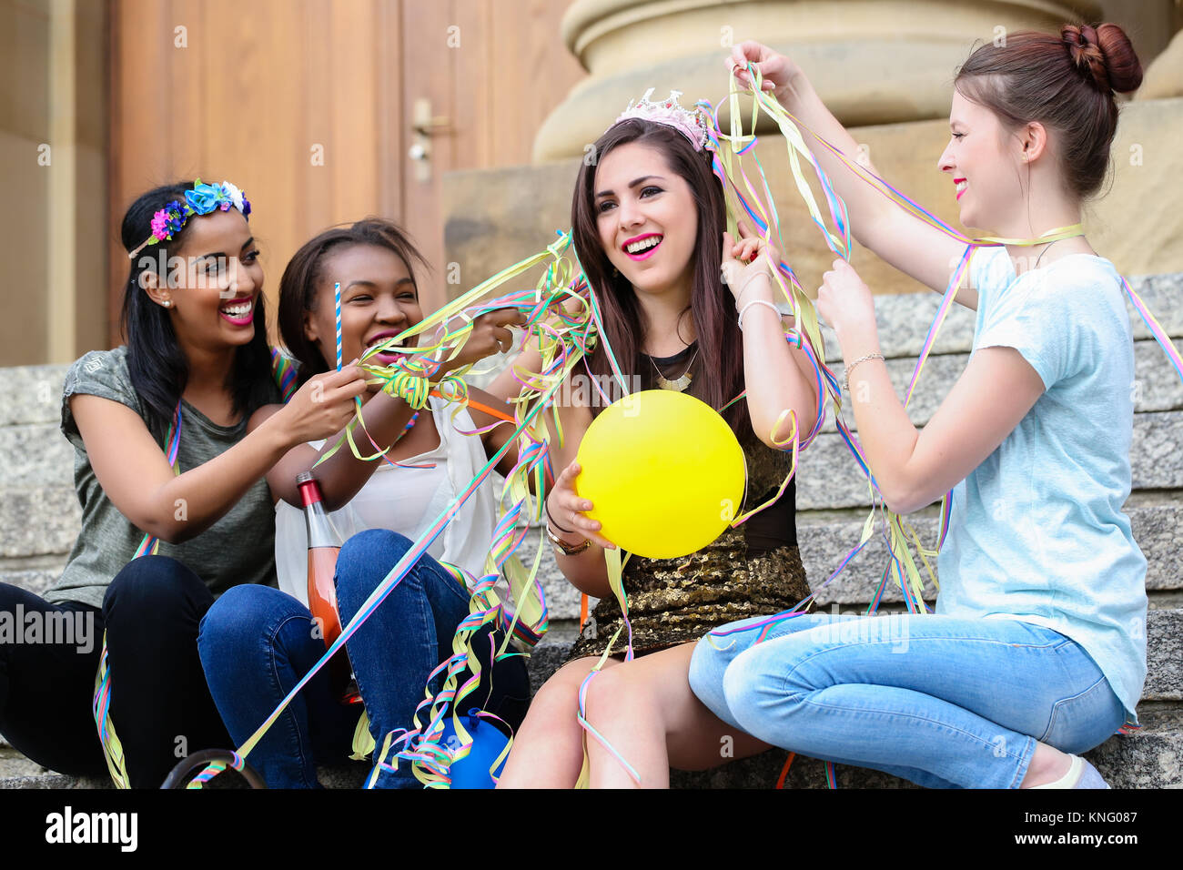 Amici decorano la sposa con party streamers Foto Stock