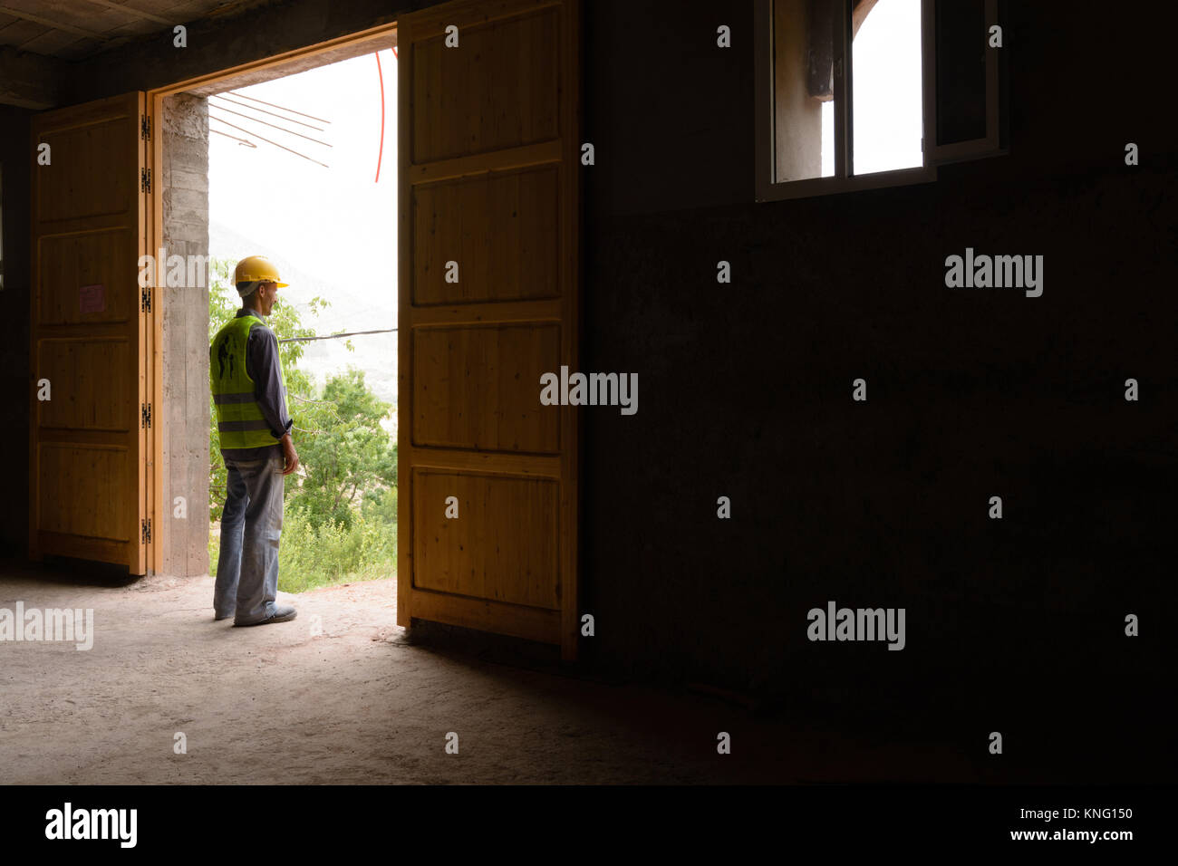 Lavoratore marocchino guardando attraverso una grande porta Foto Stock