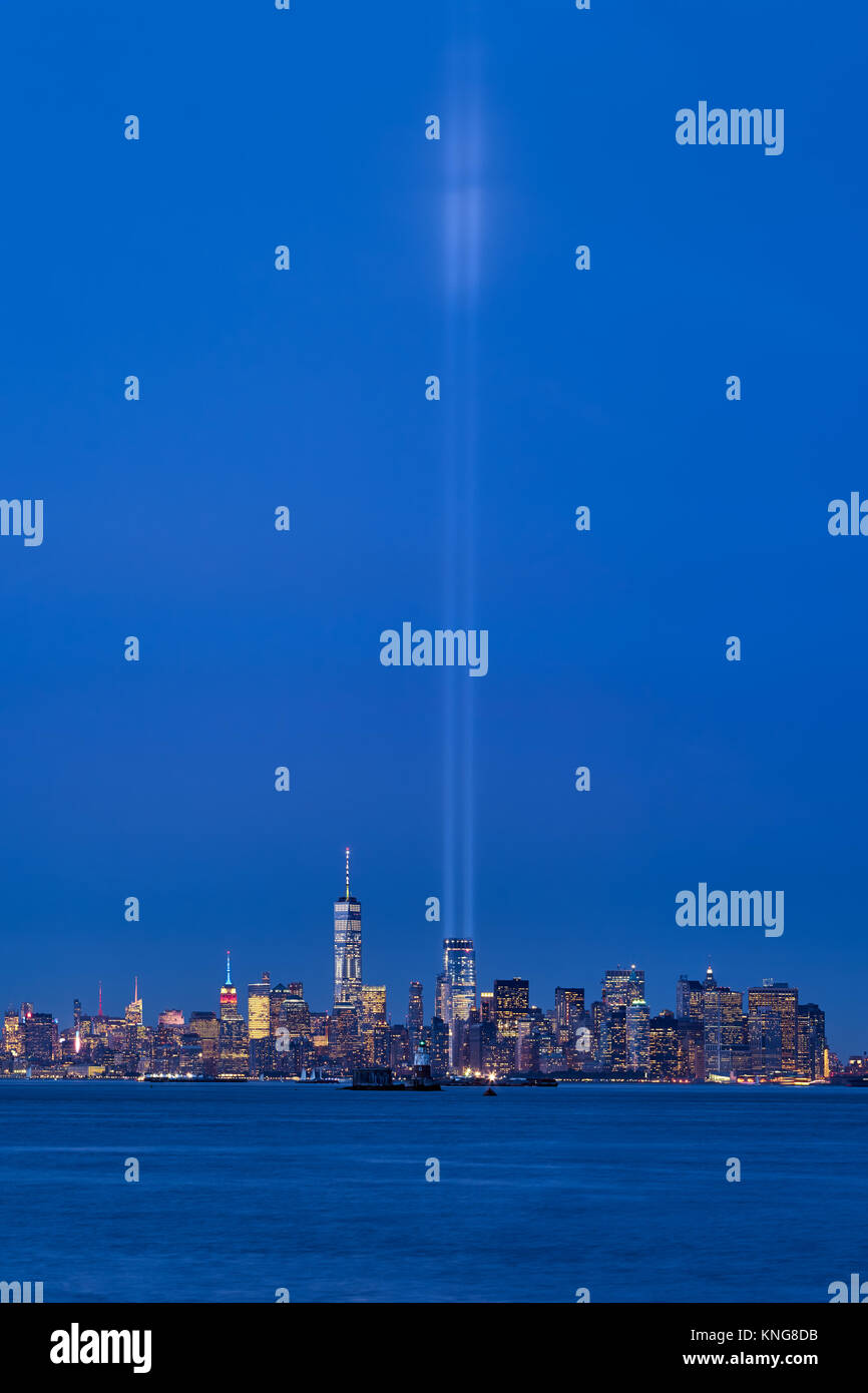 New York skyline della città con i grattacieli e i due fasci del tributo in luce. La parte inferiore di Manhattan, il Quartiere Finanziario, il porto di New York Foto Stock