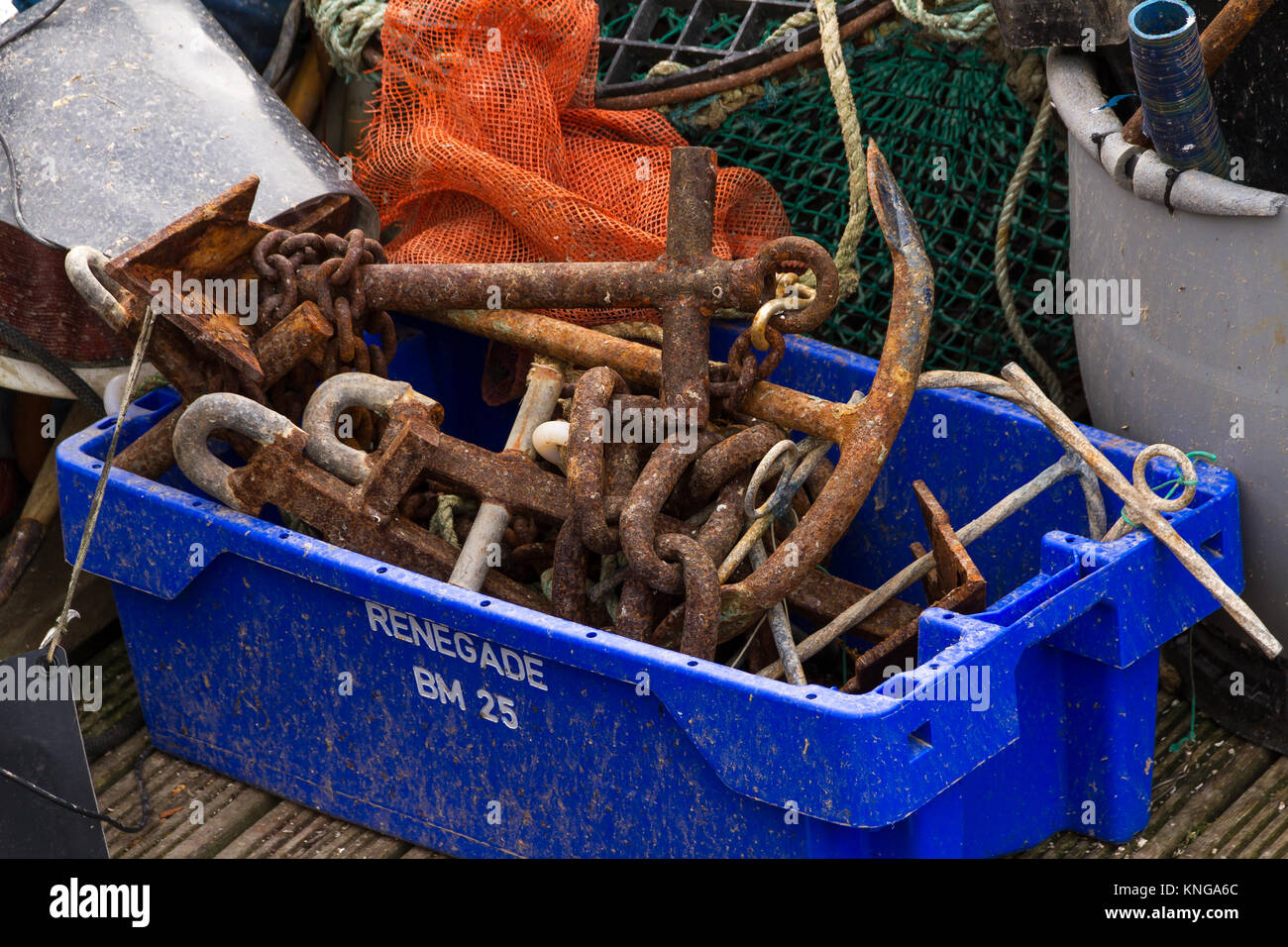 Barca generale ed industria della pesca attrezzature impilati sul lato acqua a Brixham Harbour. Brixham, Torbay, DEVON REGNO UNITO Foto Stock